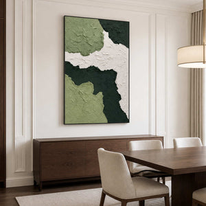 Black framed green abstract artwork above a walnut sideboard beside a dining table.