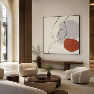 Cream abstract artwork behind rounded lounge chairs and a low table.