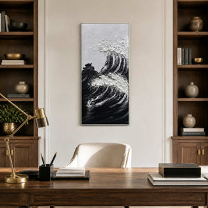 Silver framed narrow wave painting with white crests between wooden bookshelves in a study.