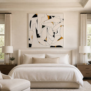 Square cream-and-black abstract artwork above a light upholstered bed.