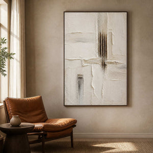 Minimalist relief painting beside a leather chair in a reading nook.