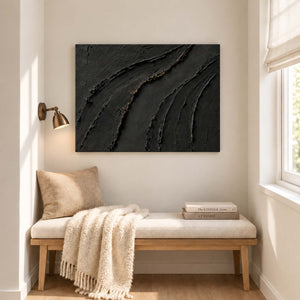 Sweeping raised black ridges with subtle gold accents without an outer frame, displayed beside seating in a lounge.