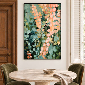 Cascading peach and blush leaves against deep green foliage in a black frame, displayed above a dining table.