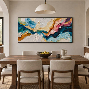 Blue and pink abstract artwork above a wood dining table beneath a cream dome pendant.