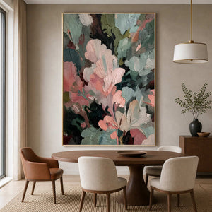 Gold framed pink and green textured painting above a round wooden dining table.
