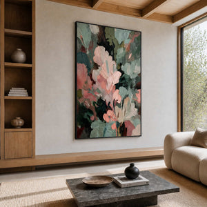 Black framed pink and green abstract painting beside a sofa in a sunlit living room.