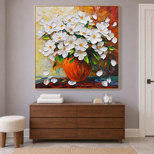 Flower painting above a wooden cabinet with towels on a lilac wall.