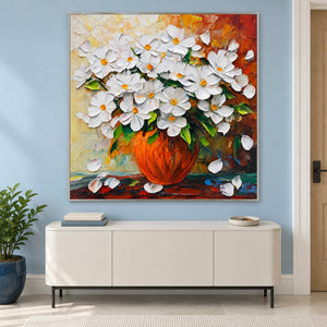Orange-vase artwork above a white sideboard on a blue wall.