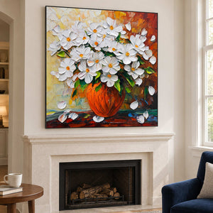 Floral vase artwork above a pale fireplace near a blue chair.
