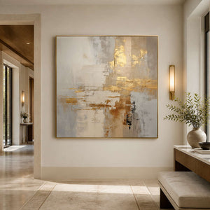 Gold framed neutral abstract artwork on a hallway wall beside a console and bench.