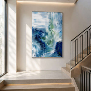 Blue, white, and sage vertical artwork beside a modern staircase.