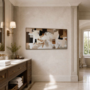 Wood framed earthy abstract artwork beside a vanity in a bathroom dry area.