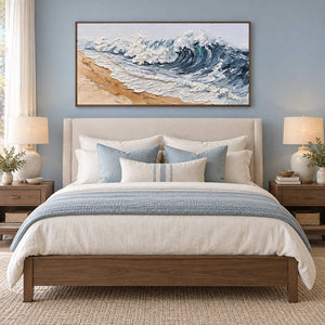 A Letter from the Waves in a wood frame above a cream bed with blue-gray cushions and a matching throw.