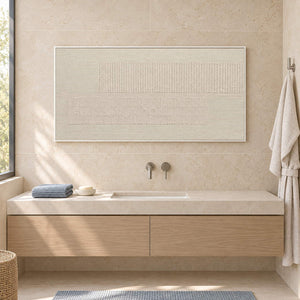 Panoramic ivory relief painting with fine grooves and geometric fields in a white frame beside a bathroom vanity.