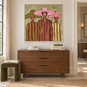A Meeting in Style in a white frame above a wood cabinet with folded towels beside a bathroom vanity.