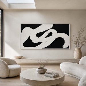 White framed black and white artwork above rounded seating in a bright lounge.