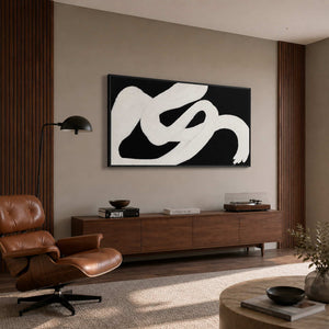 Black framed abstract painting above a record player beside a leather listening chair.