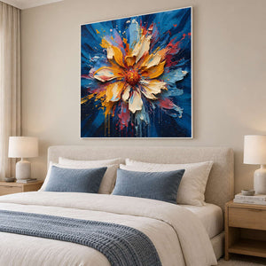 Square flower painting above a cream upholstered bed with blue-gray cushions and throw.