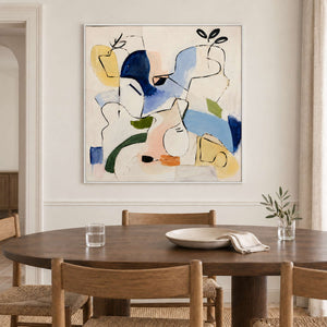 Loose black outlines and blue, yellow and green abstract shapes in a white frame, displayed above a dining table.