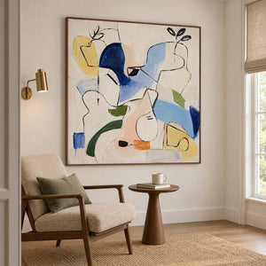 Loose black outlines and blue, yellow and green abstract shapes in a brown wood frame, displayed beside seating in a lounge.