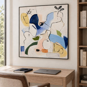 Loose black outlines and blue, yellow and green abstract shapes in a black frame, displayed in a home office.