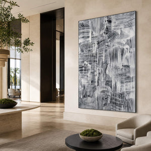 Vertical abstract painting in a lounge with pale walls and a dark round table.