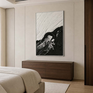 White framed monochrome artwork above a walnut dresser beside a neutral bed.