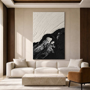 Black and white textured artwork above a cream sofa and stone coffee table.