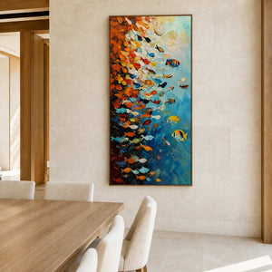 Wood framed fish artwork beside a light wooden dining table and cream chairs.