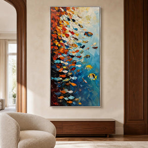 Silver framed fish artwork above a walnut console beside a rounded cream lounge chair.