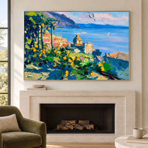 Coastal landscape above a pale fireplace beside a green armchair.