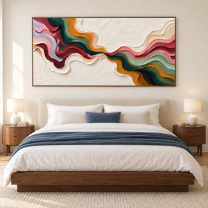 Curving color artwork above a bed with white bedding and a blue throw.