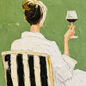 Close detail of raised white clothing, striped chair, and a hand holding red wine.