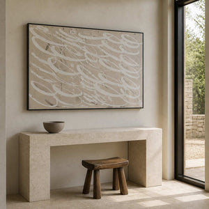 Black framed pale looping wall art above a stone entryway console.