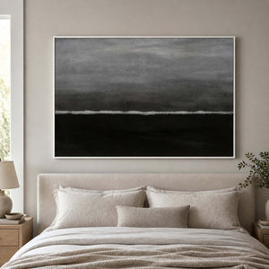 White framed horizontal wave abstraction above a padded headboard in a neutral bedroom.