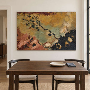 Weathered ochre, moss green and rust tones crossed by dark marks without an outer frame, displayed above a dining table.