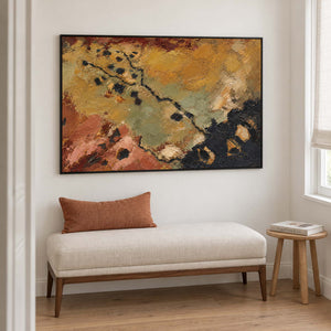 Weathered ochre, moss green and rust tones crossed by dark marks in a black frame, displayed beside seating in a lounge.