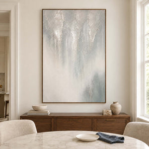Soft gray and ivory vertical textures fading into pale blue in a brown wood frame, displayed above a dining table.