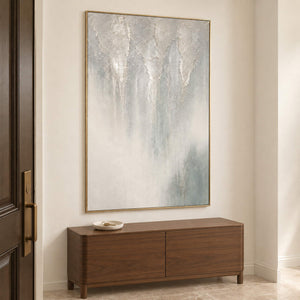 Soft gray and ivory vertical textures fading into pale blue in a gold frame, displayed above an entryway console.