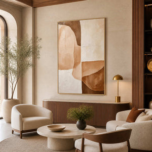 Gold-framed curved abstract artwork above a fluted wood console in a warm hotel lounge with cream chairs.