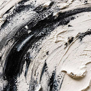 Close view of rough white paint ridges crossed by sweeping black and gray strokes.