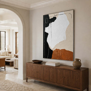 Silver-framed abstract wall art above a wooden console beside an arched doorway.