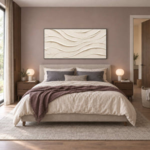 An Unhurried Flow in a black frame above a neutral bed with gray pillows, a brown throw and round bedside lamps.