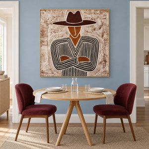 Brown-hat portrait over a round pale table with two burgundy dining chairs.