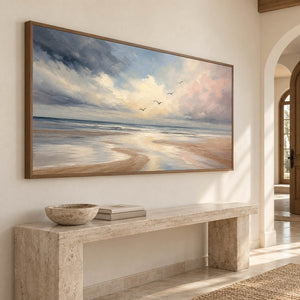 Hand-painted coastal wall art with pale blue, blush, and ivory shoreline, displayed in an entryway in a brown wood frame.