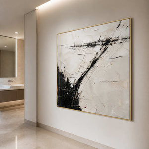 Square black and ivory wall art in a bathroom with a gold frame.