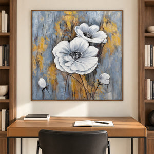 Artwork showing two large white flowers and small buds on a blue-gray ground with ochre marks in a study with a desk, with a brown wood-look frame.