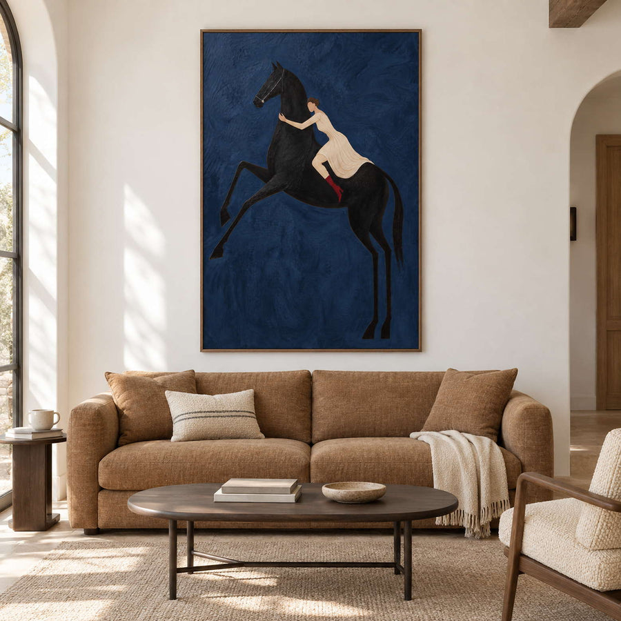 Blue rearing-horse artwork above a tan sofa and dark oval table.