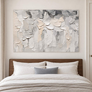 Overlapping ivory and gray raised strokes on a pale ground without an outer frame, displayed above a bed.