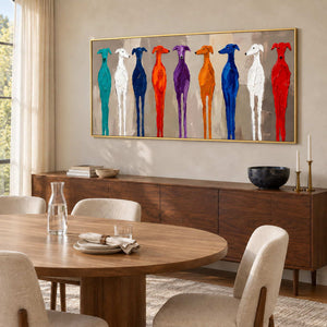 Cheerful Company in a gold frame above a dark wood sideboard beside a round dining table and cream chairs.